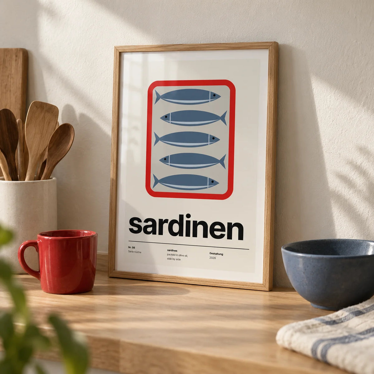 Sardine Print, a small A4 framed print leaning on a pale oak kitchen worktop