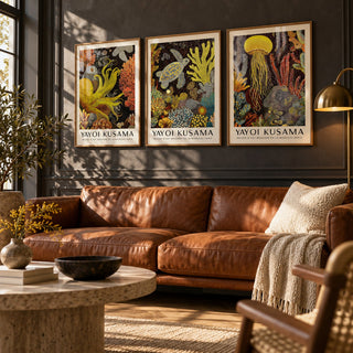 Sea Life Prints Set of 3 styled above a cognac leather sofa on a charcoal limewash wall: Golden Tentacle, Turtle Drift and Luminous Drift shown framed side by side (frames not included)