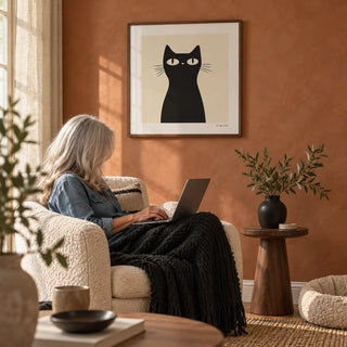 Simple Black Cat Art, framed on the wall of a warm living room with a terracotta limewashed wall
