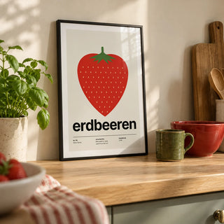 Strawberry Print, a small A4 framed print leaning on a pale oak kitchen worktop