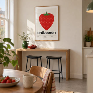 Strawberry Print, framed on the wall of a small open-plan dining area in a UK maisonette with a cream wall and a slim oak breakfast bar against it in a kitchen