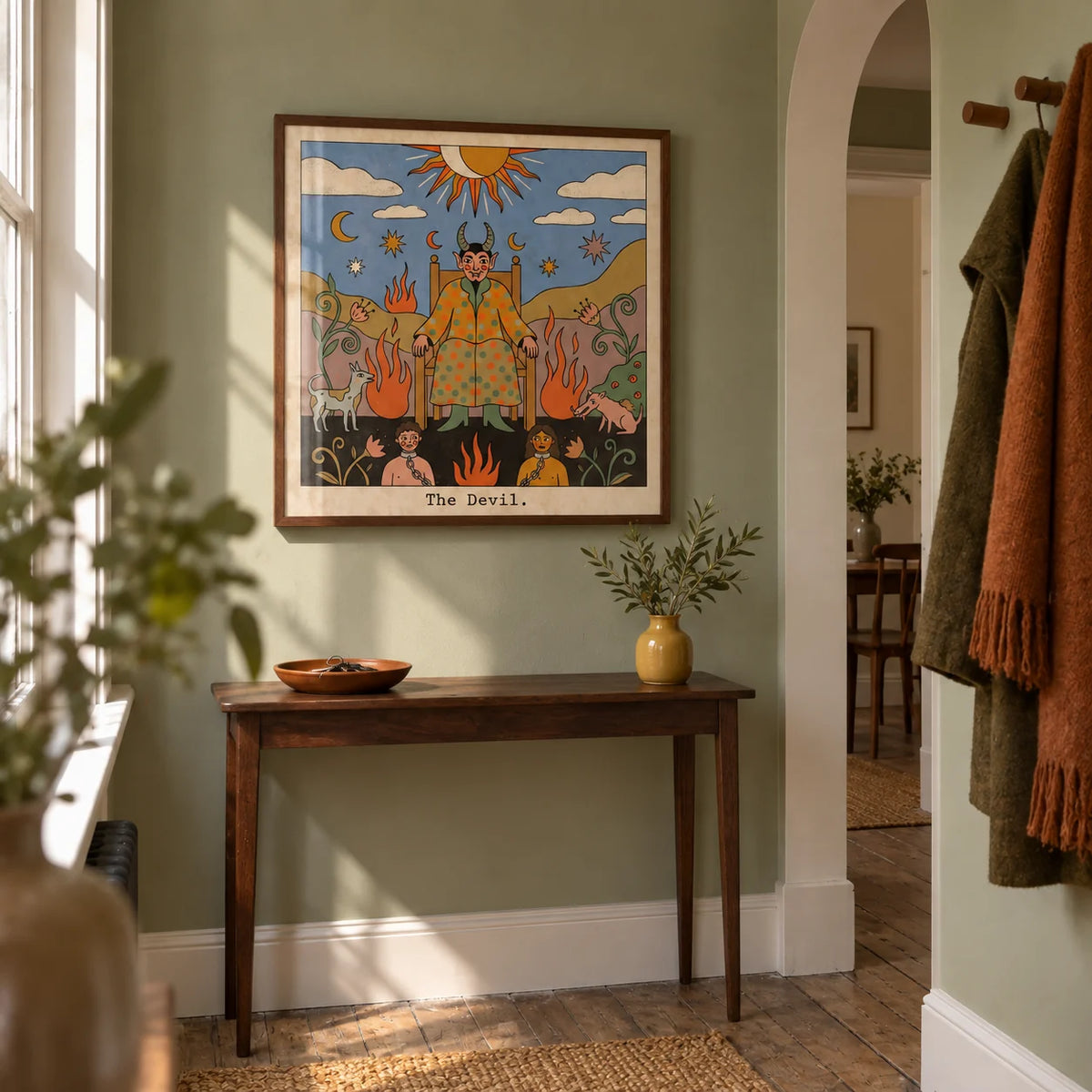 Tarot Card Devil Art, framed on the wall of a narrow hallway in a restored UK terrace with muted sage green walls and stripped floorboards