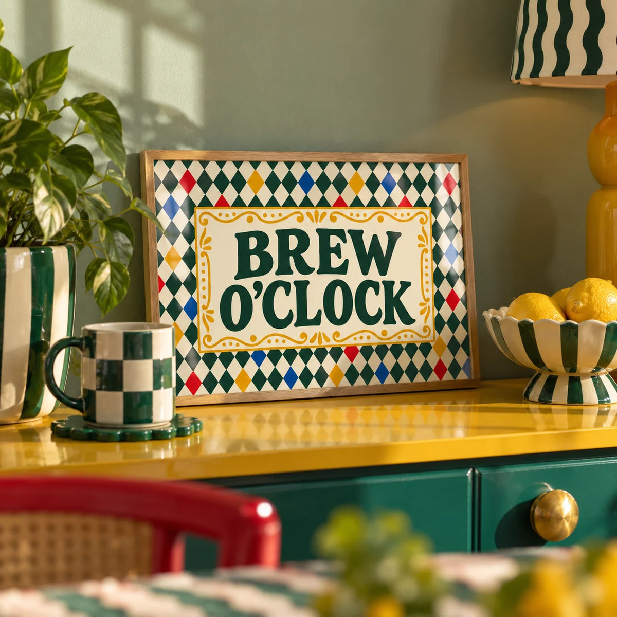 Tea Print, a small A4 framed print leaning on a colourful lacquered shelf in a living room