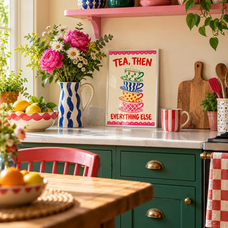 Teacup Tower Print, a small A4 framed print leaning on a kitchen worktop