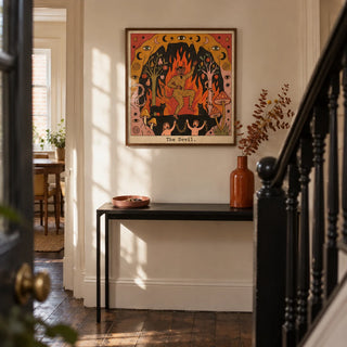 The Devil Tarot Card Art, framed on the wall of a narrow hallway in a UK terraced house with warm cream walls
