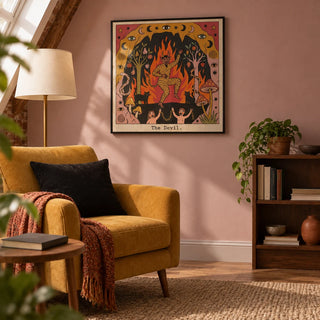 The Devil Tarot Card Art, framed on the wall of a quiet reading alcove in a UK loft flat with a pale dusty pink wall and a low walnut bookshelf in a living room