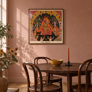 The Devil Tarot Card Art, framed on the wall of a warm dining room in a UK flat with muted dusty pink plaster walls and a plain timber floor