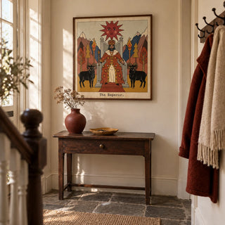 The Emperor Tarot Card Art, framed on the wall of a welcoming hallway in a period terraced home with cream walls and worn flagstone flooring