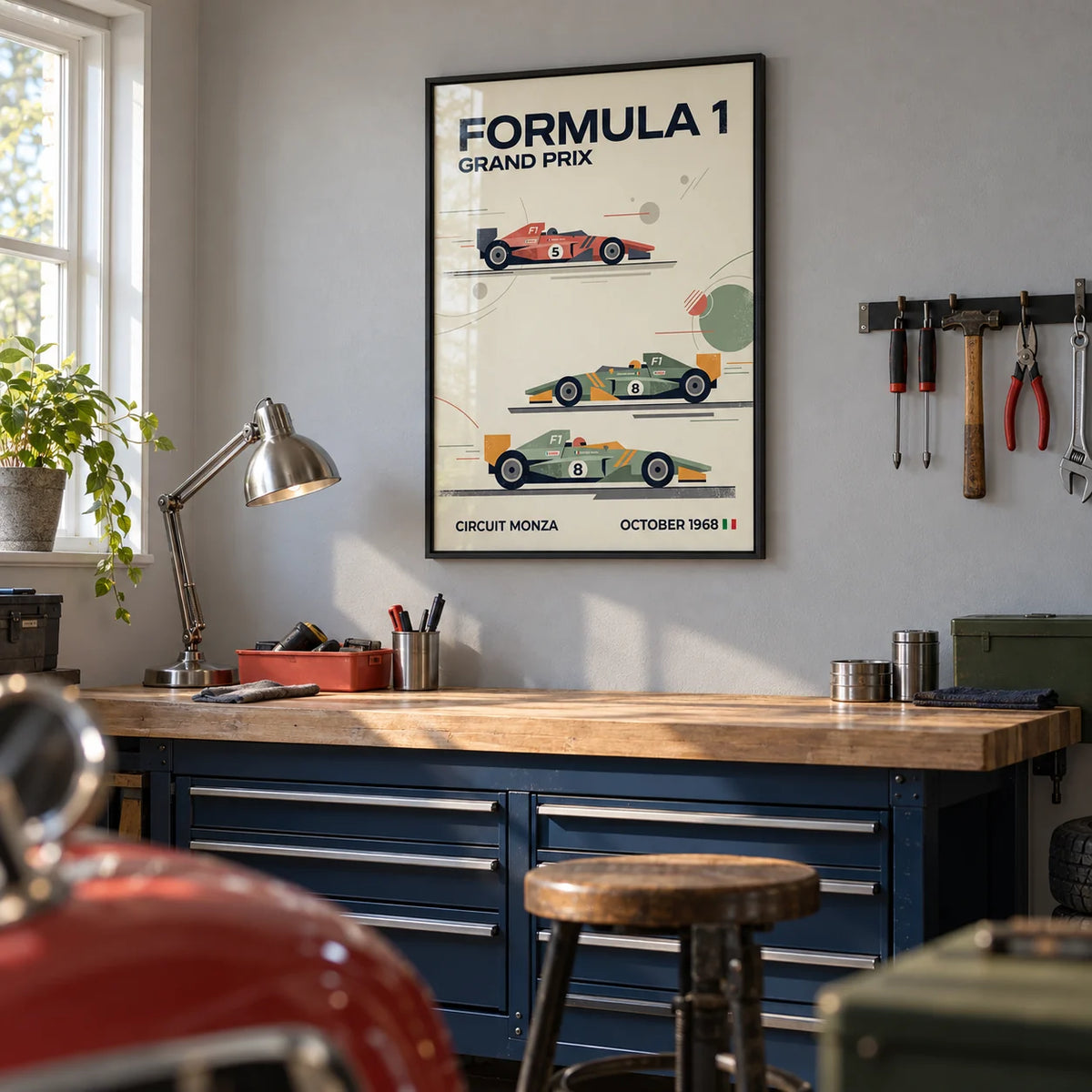 Three Classic Racing Cars Poster, framed on the wall of a tidy hobby garage in a UK semi-detached home with a pale grey painted wall and sealed concrete floor