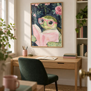 Turtle Reading Art Print, framed on the wall of a compact home study in a UK maisonette with a cream wall and a recessed shelf of books with unlettered spines
