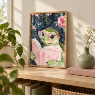 Turtle Reading Art Print, a small A4 framed print leaning on a pale oak bookshelf in a living room