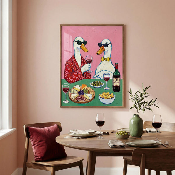 Dining room with a table set for a meal, a plant, and a framed artwork of two ducks at a dinner table.