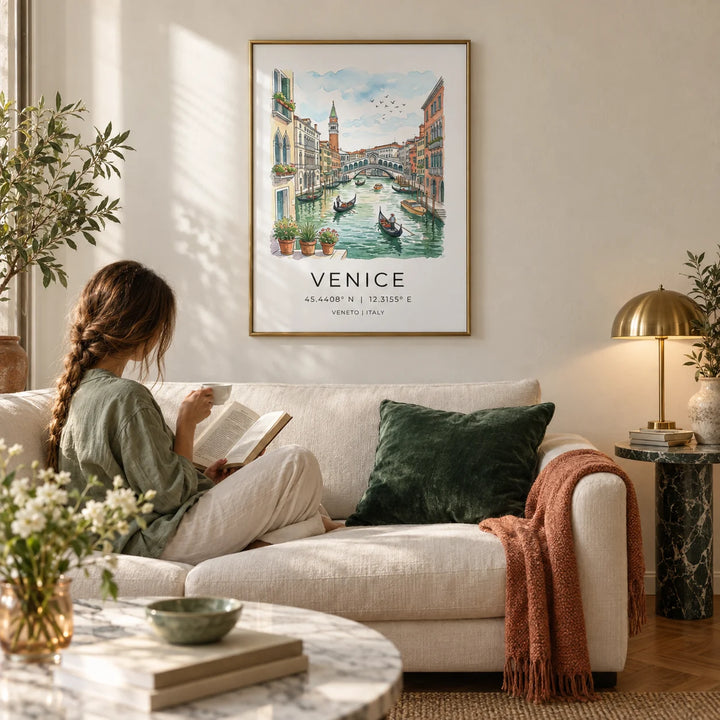 Venice Canal Art Print, framed on the wall of an elegant Italian-style living room with a warm white plaster wall and a parquet floor