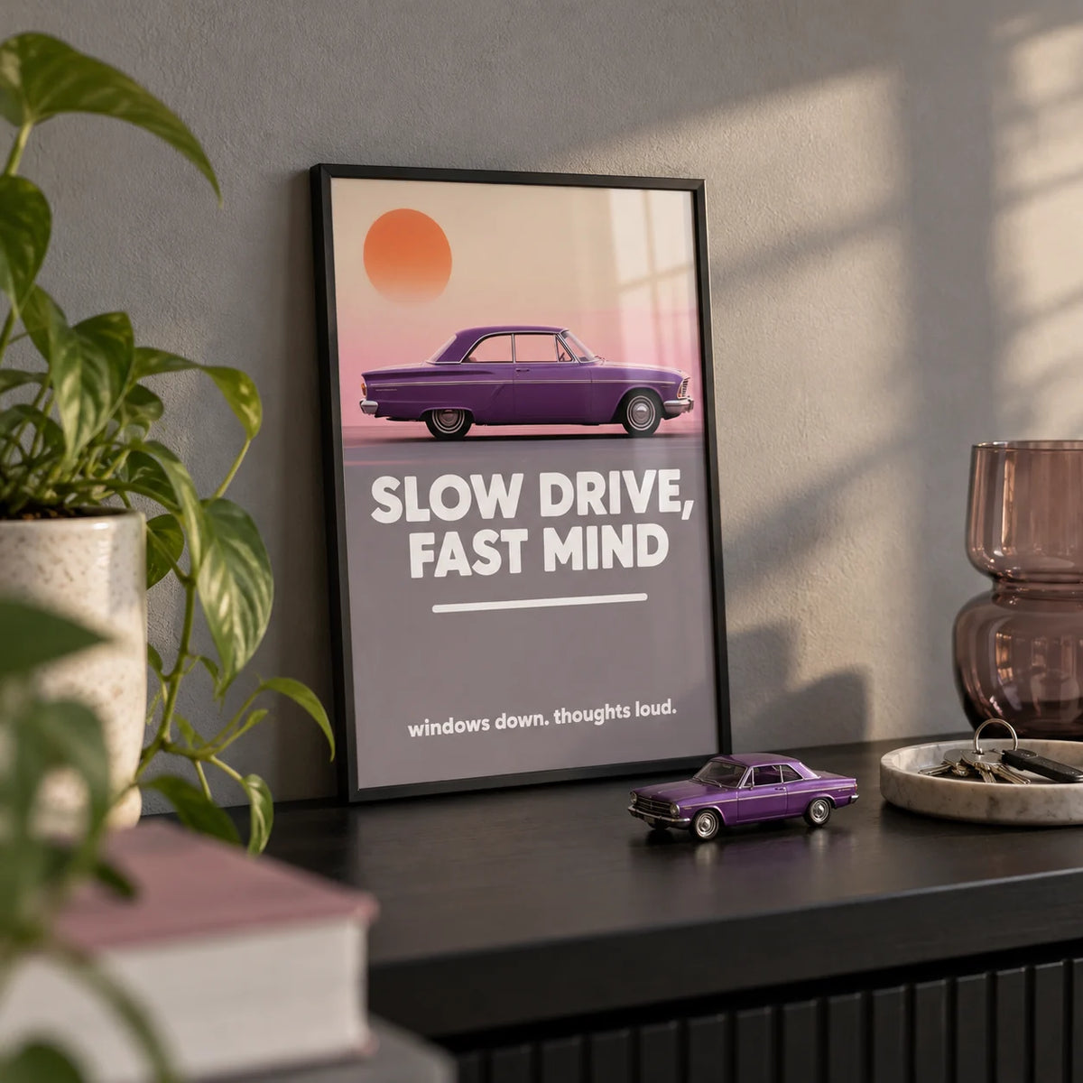 Vintage Car Wall Art, a small A4 framed print leaning on a black shelf in a living room