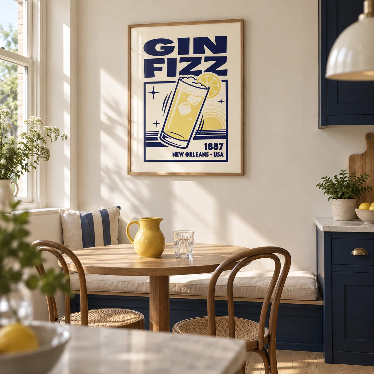 Vintage Gin Fizz Print, framed on the wall of a bright kitchen breakfast nook in a renovated UK terrace with plain cream walls and navy lower cabinets
