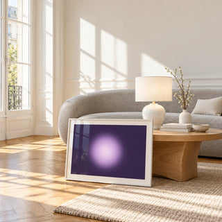Violet Print, framed and leaning against a coffee table in a bright living room