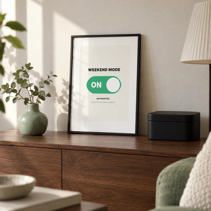 Weekend Poster, a small A4 framed print leaning on a walnut sideboard in a living room