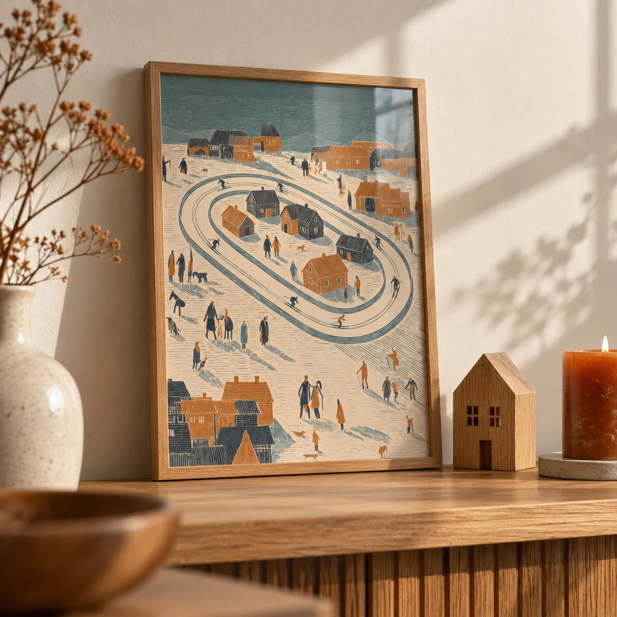 Winter Village Art Print, a small A4 framed print leaning on an oak shelf in a living room