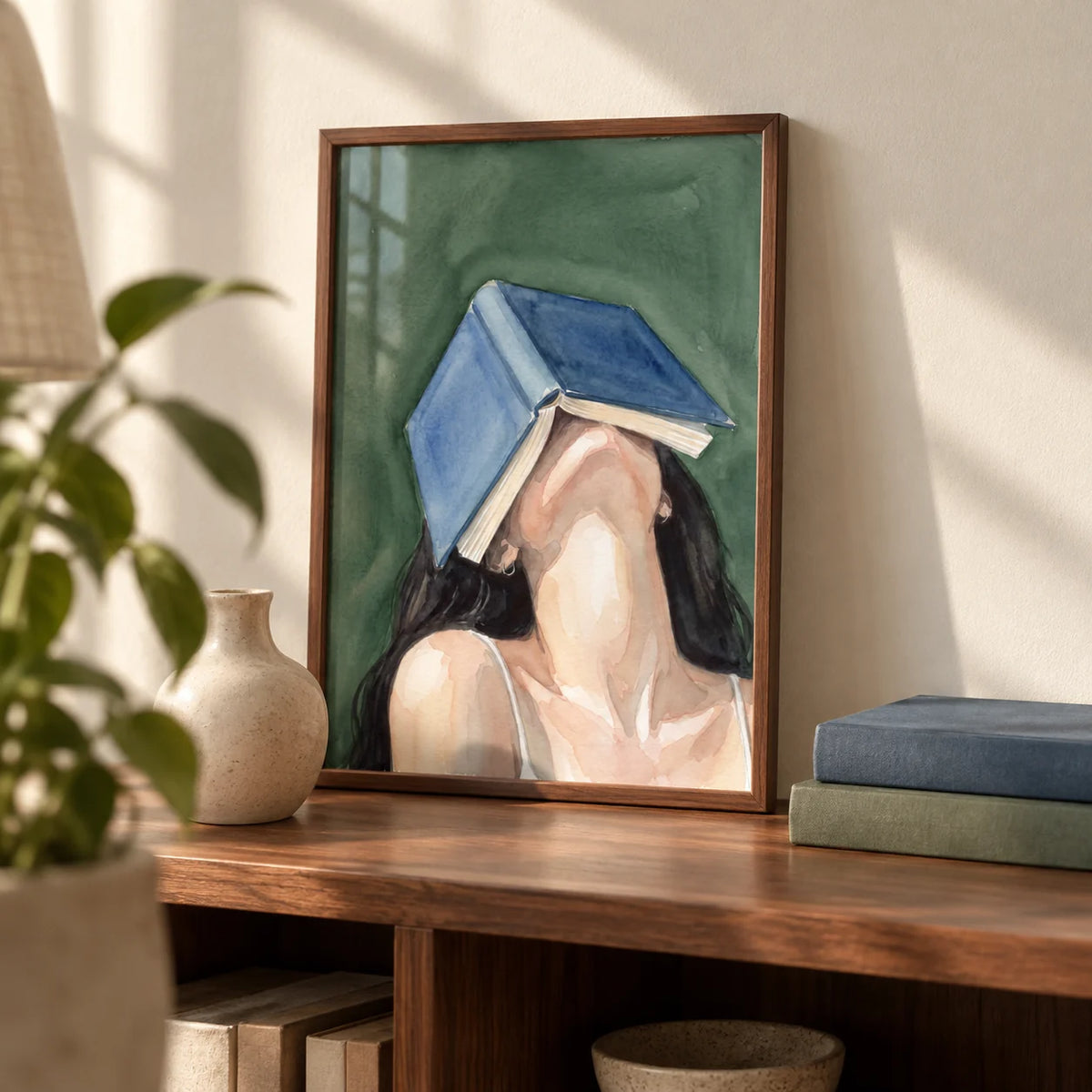 Woman Reading Portrait Print, a small A4 framed print leaning on a walnut bookshelf in a living room