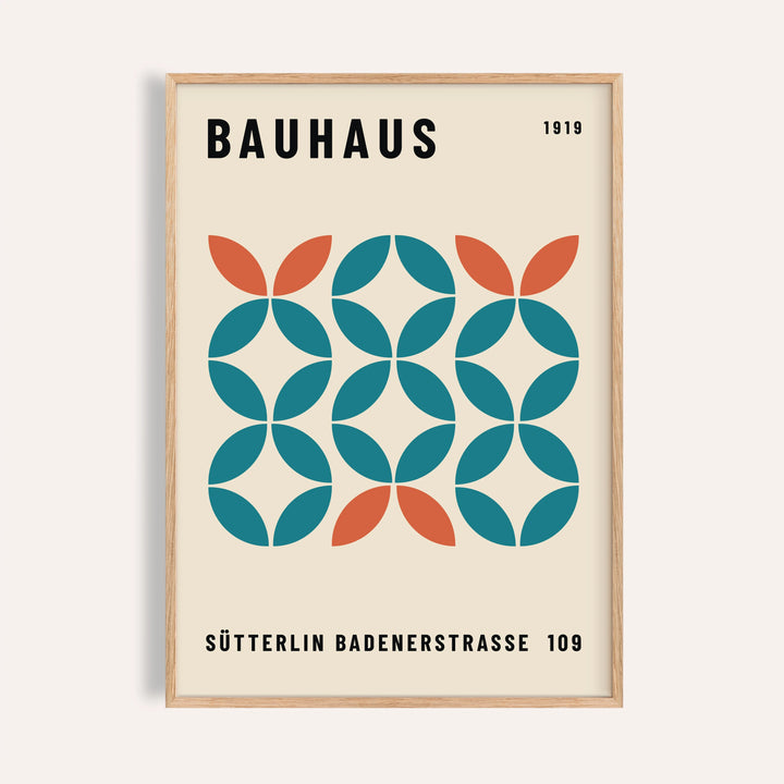 Framed print showing a geometric bauhaus pattern with teal and orange shapes on cream background