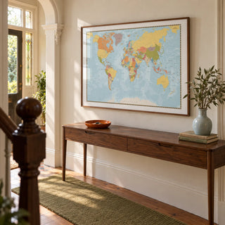 World Map Print, framed on the wall of a welcoming hallway in a Victorian terrace with cream plaster walls and restored timber flooring