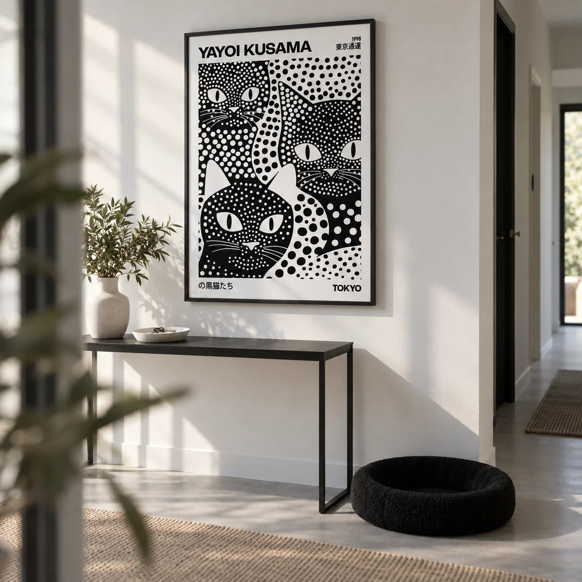 Yayoi Kusama Black Cats, framed on the wall of a crisp hallway with a white wall and a pale grey floor
