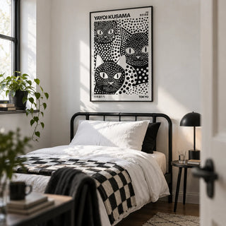Yayoi Kusama Black Cats, framed on the wall of a crisp monochrome single bedroom in a first flat (22-28) with a white wall