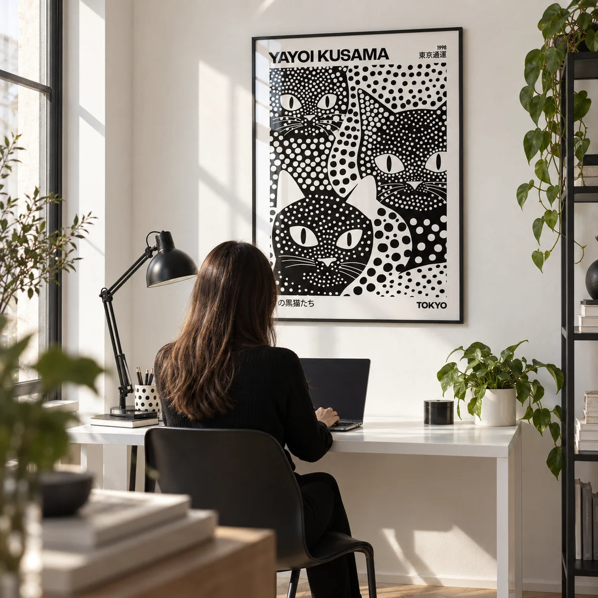Yayoi Kusama Black Cats, framed on the wall of a modern home office with a white wall