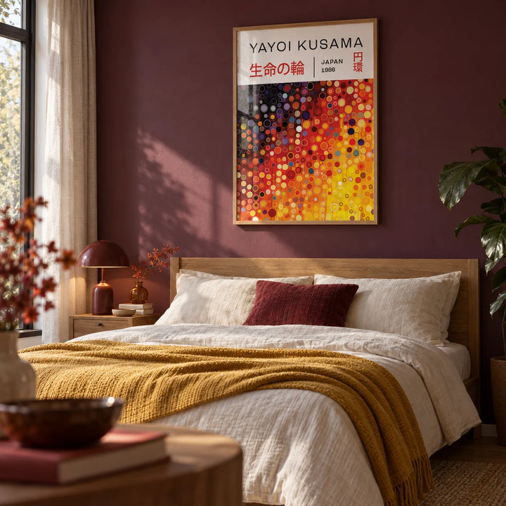 Yayoi Kusama Circles, framed on the wall of a warm modern bedroom with a deep plum painted wall