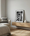 Modern living room with a zebra print framed picture on a wooden shelf.