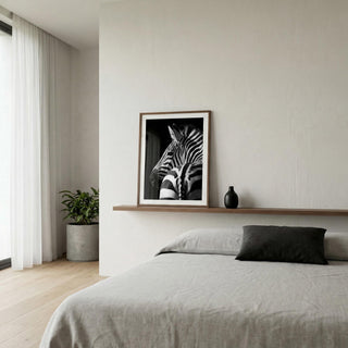 Modern bedroom with a zebra print framed picture on the wall above a bed.
