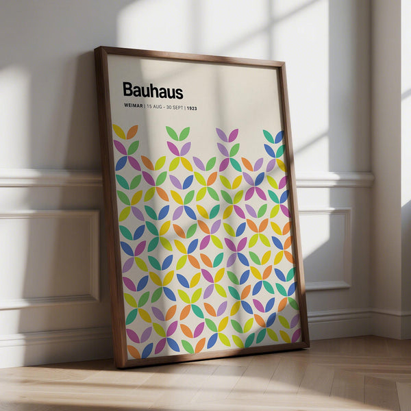 Colorful Bauhaus poster featuring overlapping petal shapes in green, purple, and yellow on a cream background.