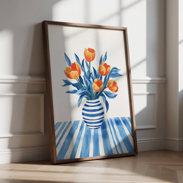 Décoration murale représentant des tulipes orange dans un vase rayé bleu posé sur une table à motifs.