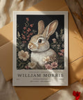 Œuvre d'art vintage inspirée de William Morris représentant un lapin brun et blanc dans un décor floral.