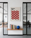 Des photos encadrées du Bauhaus sont exposées au-dessus d'un bureau minimaliste.