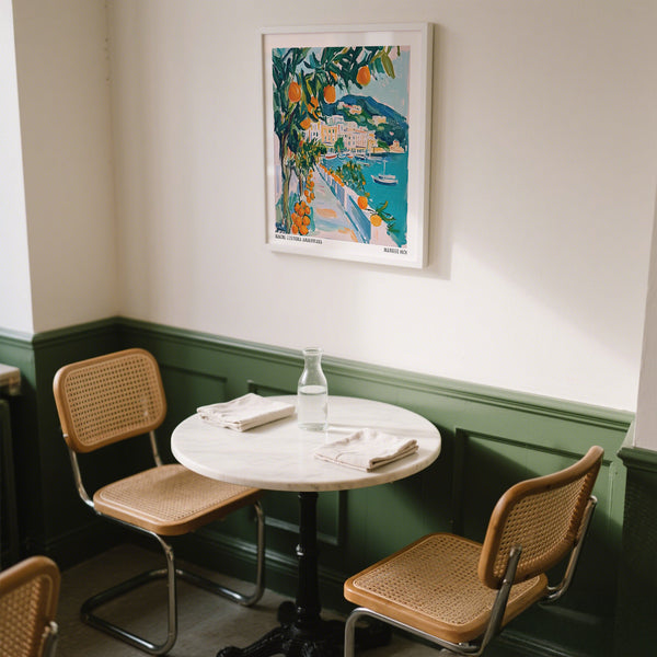 Table ronde avec des chaises dans une pièce avec une peinture colorée au mur.