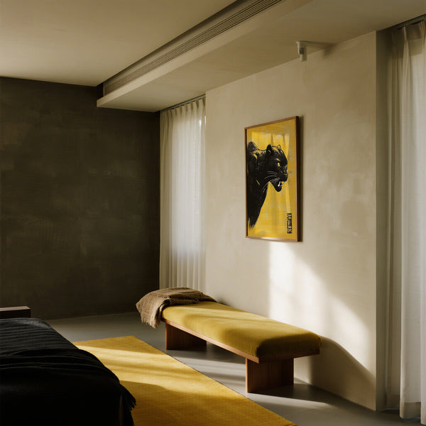 Intérieur moderne avec un banc, un tapis et une décoration murale représentant une panthère noire dans une pièce faiblement éclairée.
