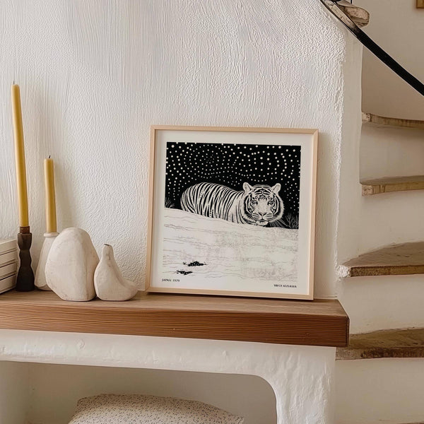 Scena innevata in bianco e nero con una tigre bianca in movimento