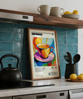 Poster colorato a tema caffè espresso su un bancone da cucina con una teiera nera e limoni.