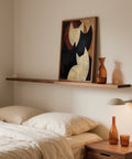 Parete della camera da letto con quadro astratto raffigurante un gatto in colori neutri