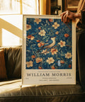 Poster artistico di William Morris con uccellino azzurro appollaiato su un ramo fiorito in calde tonalità vintage.
